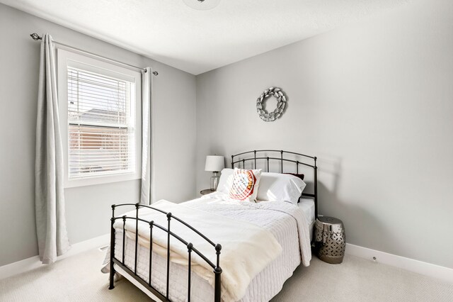 carpeted bedroom featuring baseboards