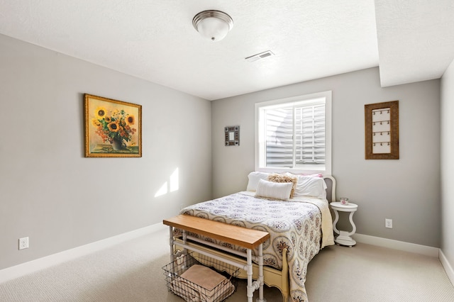 bedroom featuring visible vents, a textured ceiling, baseboards, and carpet