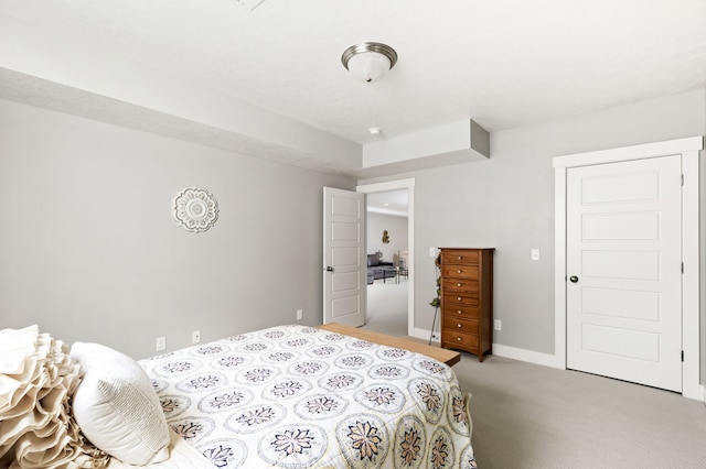 bedroom with light colored carpet and baseboards