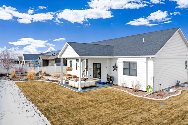 rear view of house featuring fence, a lawn, and a shingled roof