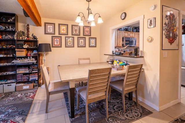 dining area featuring tile patterned floors, beamed ceiling, baseboards, and a chandelier