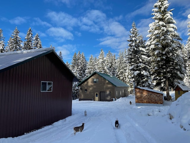 view of snow covered exterior with a detached garage