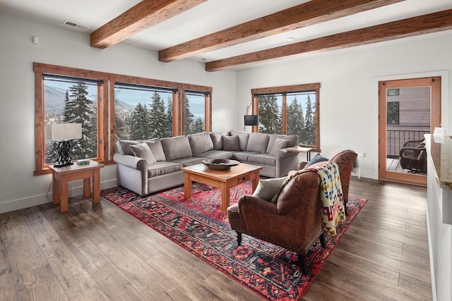 living room with beam ceiling, wood finished floors, visible vents, and baseboards