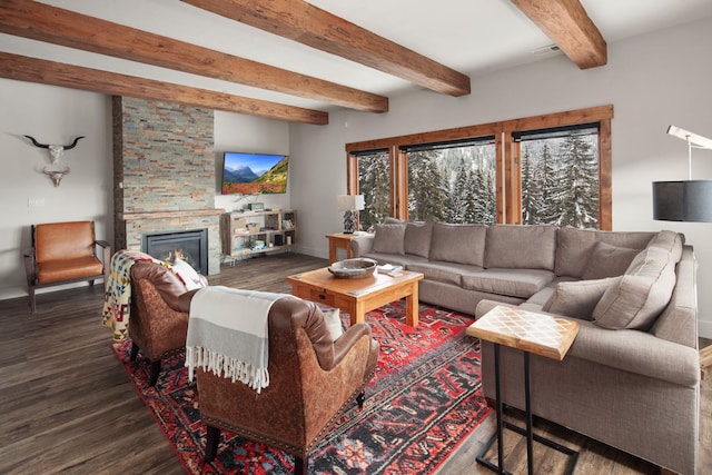 living room with a stone fireplace, beamed ceiling, baseboards, and wood finished floors