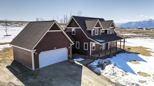 view of front facade with a mountain view, a porch, and driveway