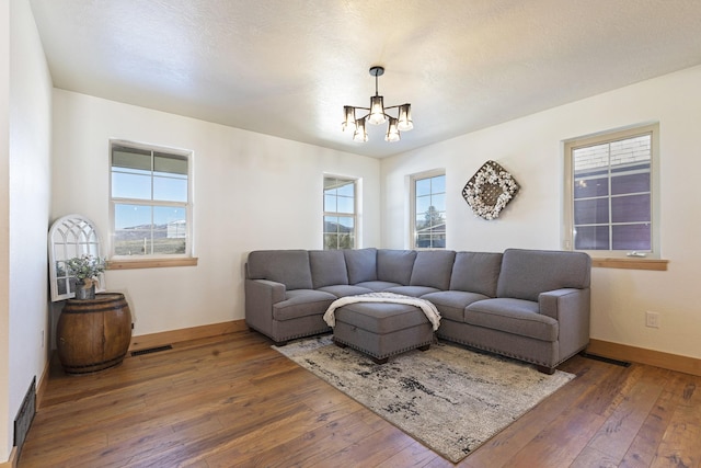 living area with visible vents, plenty of natural light, baseboards, and hardwood / wood-style floors