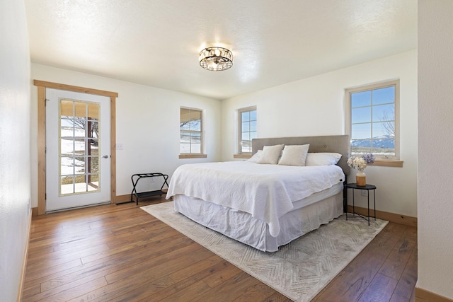 bedroom with baseboards and hardwood / wood-style flooring