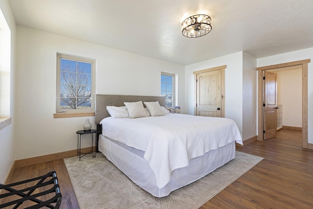 bedroom with wood finished floors and baseboards