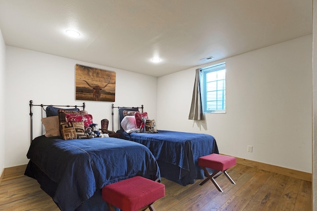 bedroom with hardwood / wood-style floors, baseboards, and visible vents