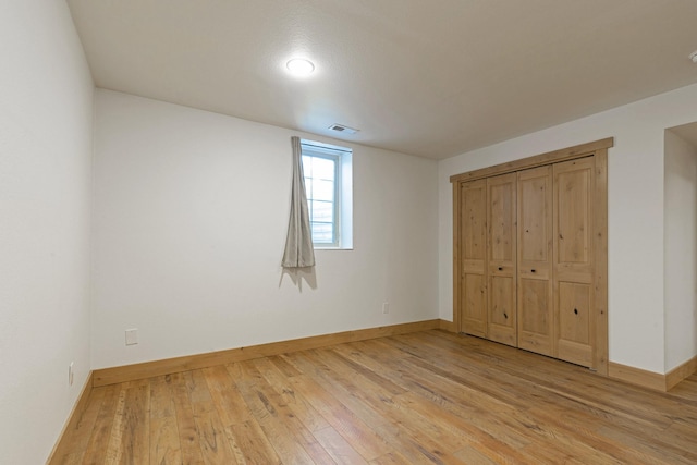 unfurnished bedroom featuring baseboards, visible vents, and light wood-type flooring