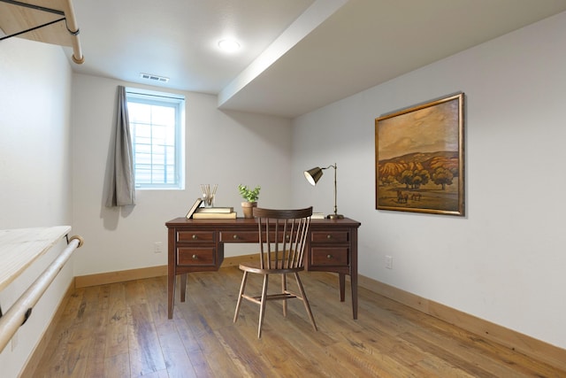 office space featuring visible vents, light wood-style flooring, and baseboards