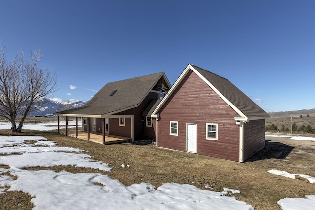 snow covered rear of property with a mountain view