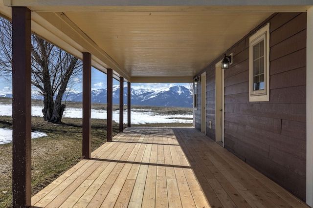 wooden terrace featuring a porch and a water and mountain view