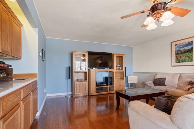 living room featuring baseboards, dark wood-type flooring, and ceiling fan