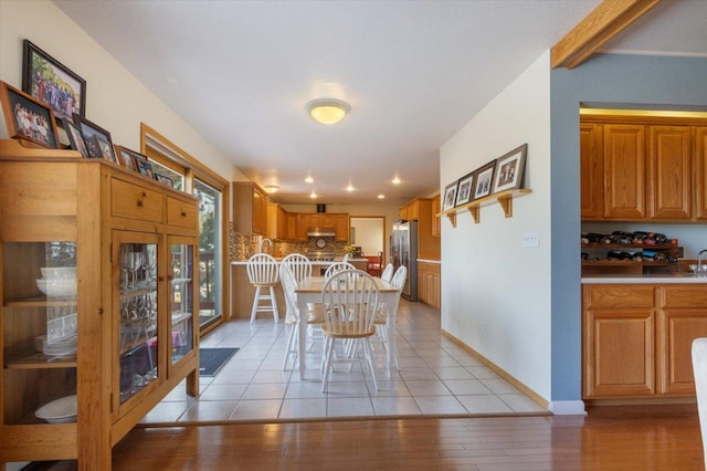 dining space featuring light tile patterned floors and baseboards