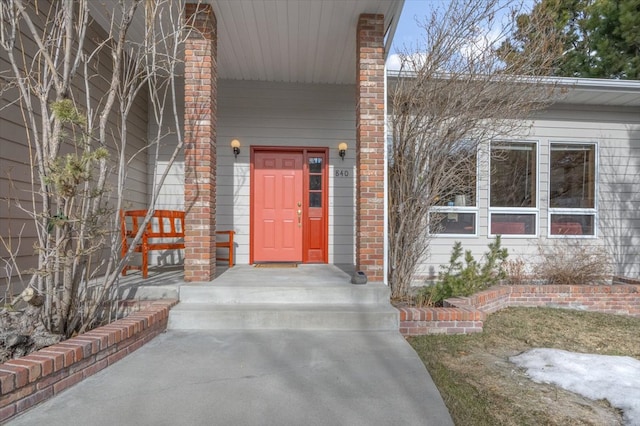 view of exterior entry featuring covered porch