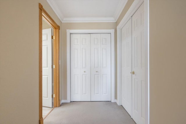 hallway featuring light carpet, baseboards, and ornamental molding