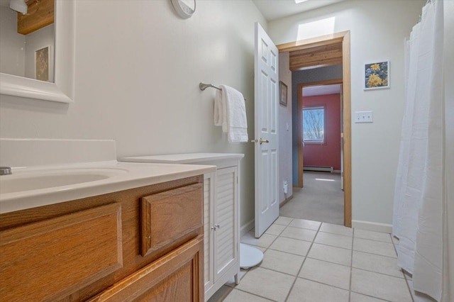 full bath featuring vanity, tile patterned floors, baseboards, and baseboard heating