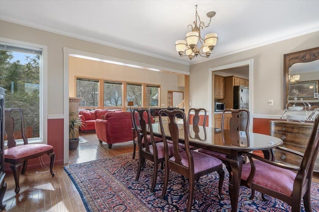 dining space featuring a chandelier, crown molding, and hardwood / wood-style flooring