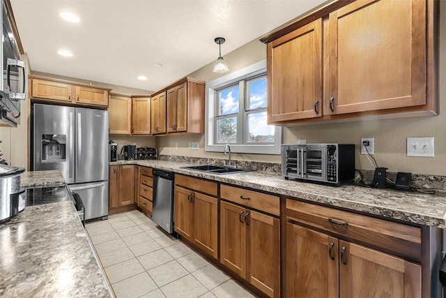 kitchen with a sink, stainless steel appliances, brown cabinetry, a toaster, and light tile patterned floors