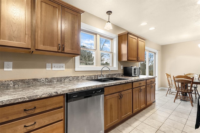 kitchen with baseboards, light tile patterned flooring, a sink, dishwasher, and brown cabinets