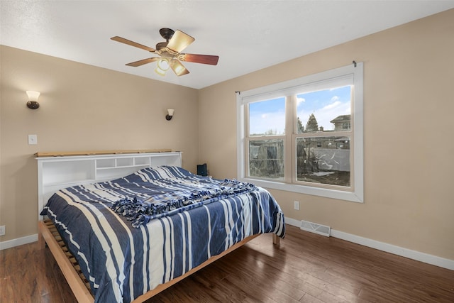 bedroom featuring visible vents, baseboards, wood-type flooring, and a ceiling fan