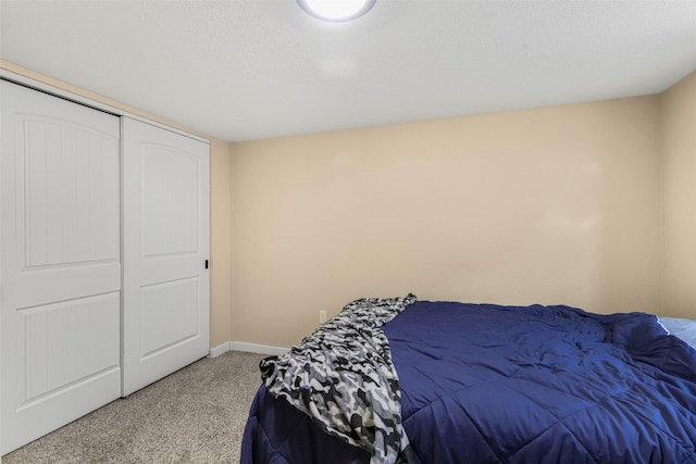 bedroom featuring a textured ceiling, baseboards, and carpet