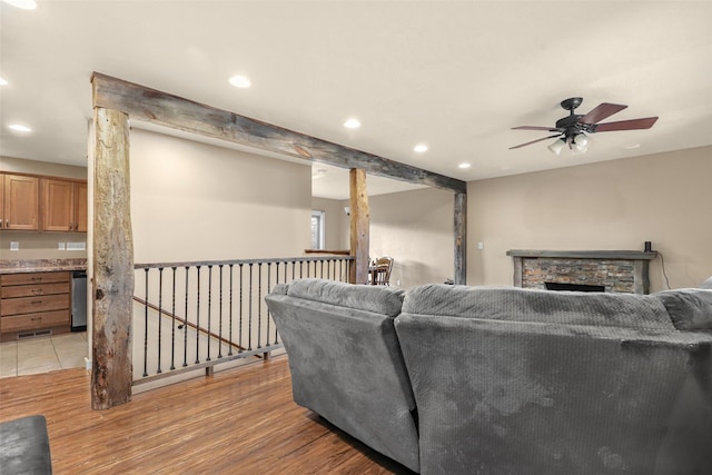 living room featuring a stone fireplace, recessed lighting, light wood finished floors, and ceiling fan