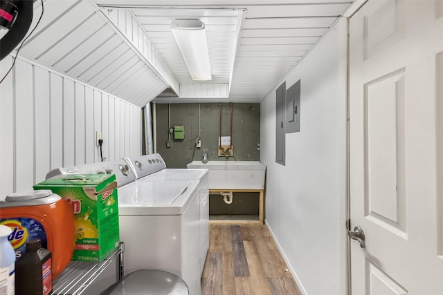 clothes washing area with a sink, wood finished floors, laundry area, and washing machine and clothes dryer