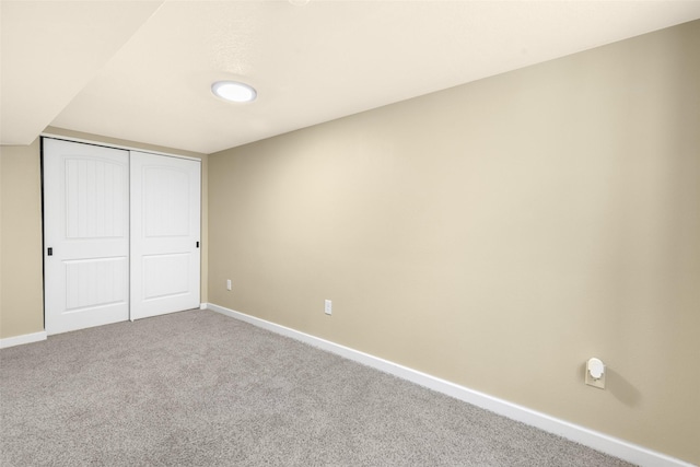 unfurnished bedroom featuring a closet, baseboards, and carpet floors