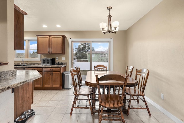 dining area featuring an inviting chandelier, light tile patterned floors, recessed lighting, and baseboards