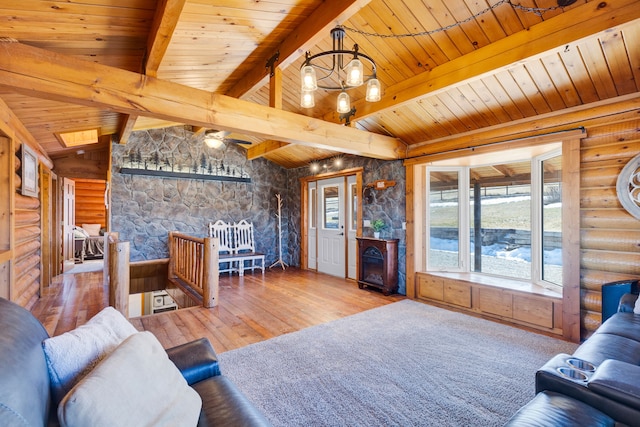 living area with lofted ceiling with beams, hardwood / wood-style floors, an inviting chandelier, log walls, and wood ceiling