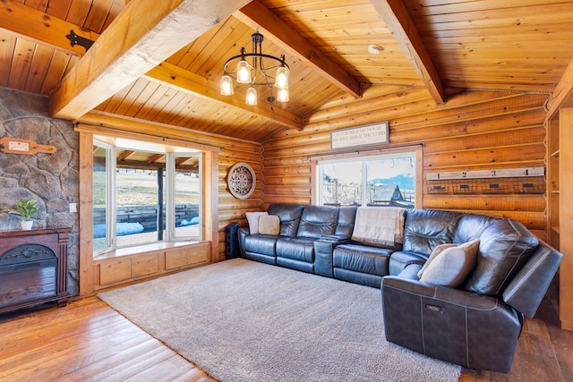 living room with lofted ceiling with beams, rustic walls, hardwood / wood-style floors, and a wealth of natural light