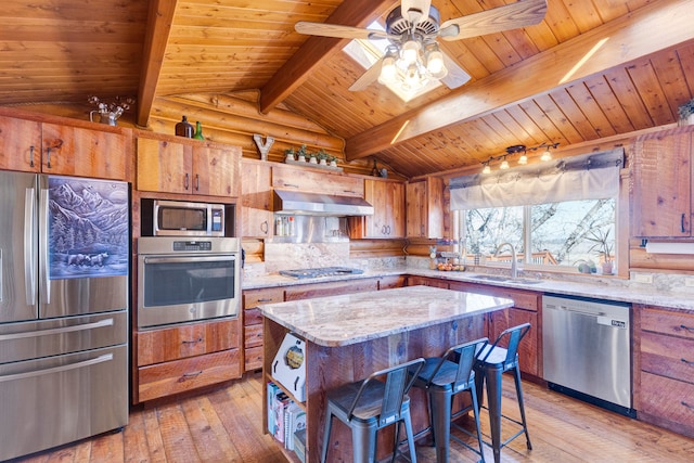 kitchen featuring brown cabinets, a sink, lofted ceiling with beams, stainless steel appliances, and exhaust hood