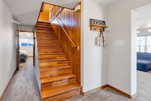 staircase featuring a wealth of natural light, baseboards, and carpet floors