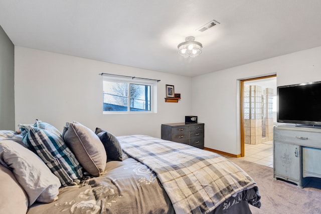 bedroom featuring light carpet, visible vents, ensuite bathroom, and baseboards