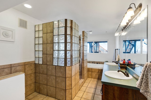 full bathroom featuring visible vents, a garden tub, a walk in shower, a sink, and tile patterned flooring