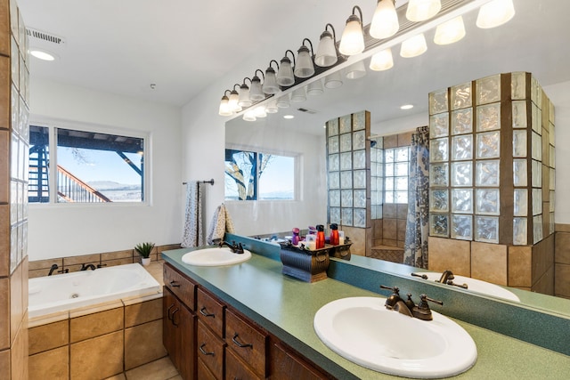 full bathroom with a tile shower, a garden tub, and a sink