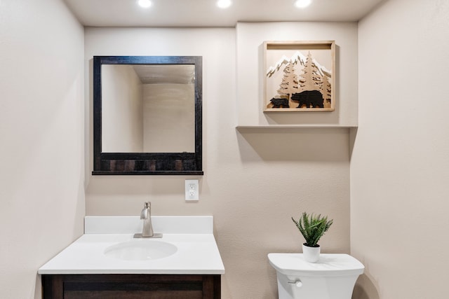 bathroom with recessed lighting, toilet, and vanity