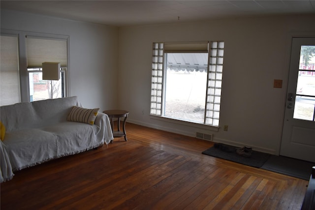 living area with visible vents, a healthy amount of sunlight, and hardwood / wood-style flooring