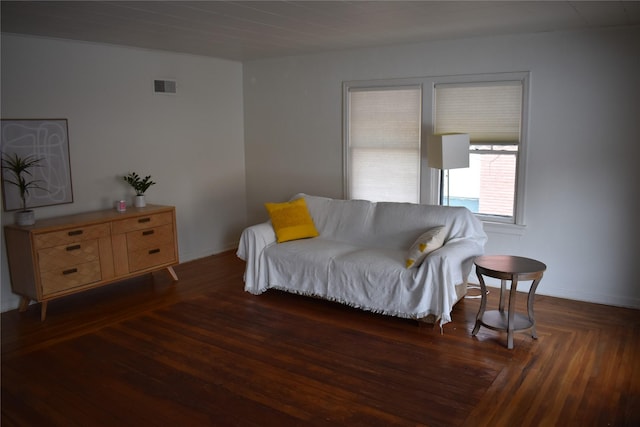 living area featuring wood finished floors, visible vents, and baseboards