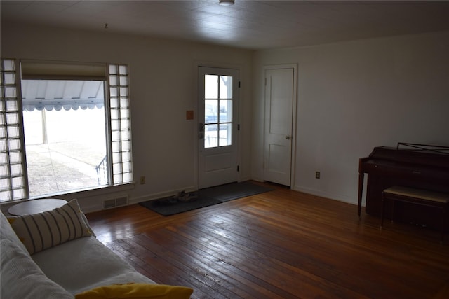 interior space featuring visible vents, plenty of natural light, baseboards, and wood-type flooring