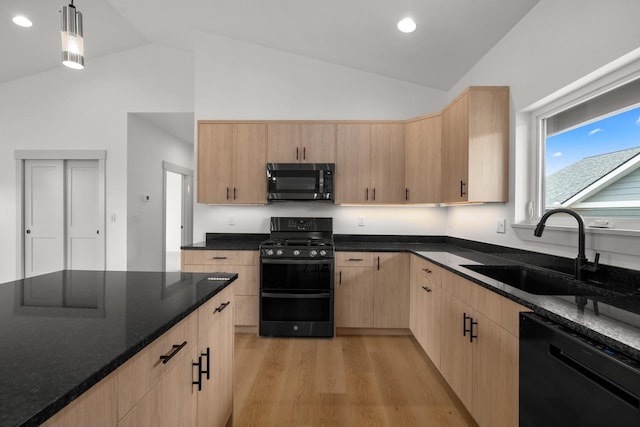 57 Hidden Cedar Loop, Columbia Falls, MT 59912 - kitchen with black appliances, light brown cabinets, high vaulted ceiling, light wood-style floors, and dark stone countertops
