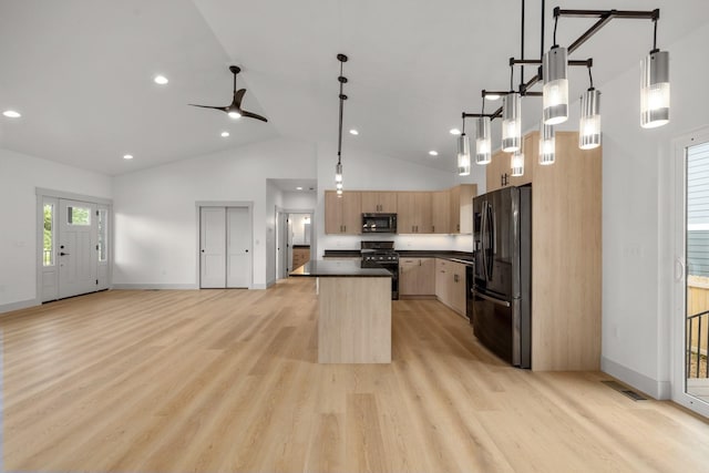 57 Hidden Cedar Loop, Columbia Falls, MT 59912 - kitchen featuring black appliances, light brown cabinets, dark countertops, high vaulted ceiling, and a center island