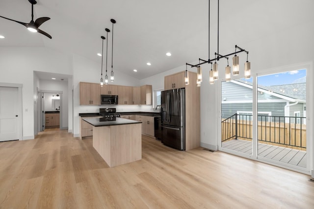 57 Hidden Cedar Loop, Columbia Falls, MT 59912 - kitchen with black appliances, light brown cabinets, a center island, dark countertops, and light wood finished floors