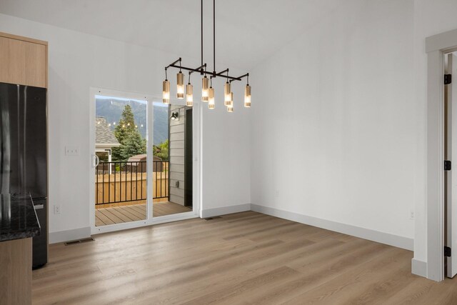 57 Hidden Cedar Loop, Columbia Falls, MT 59912 - unfurnished dining area featuring a chandelier and light wood-style flooring