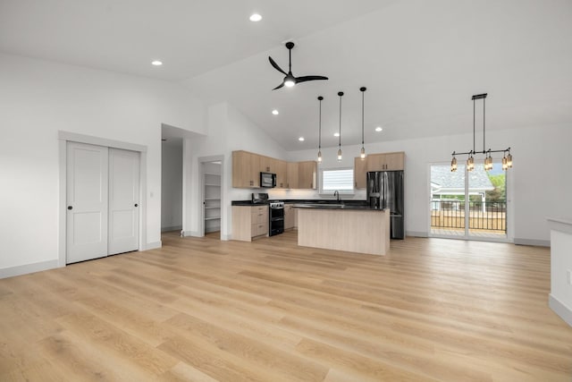 57 Hidden Cedar Loop, Columbia Falls, MT 59912 - kitchen with stainless steel appliances, light brown cabinets, open floor plan, dark countertops, and ceiling fan
