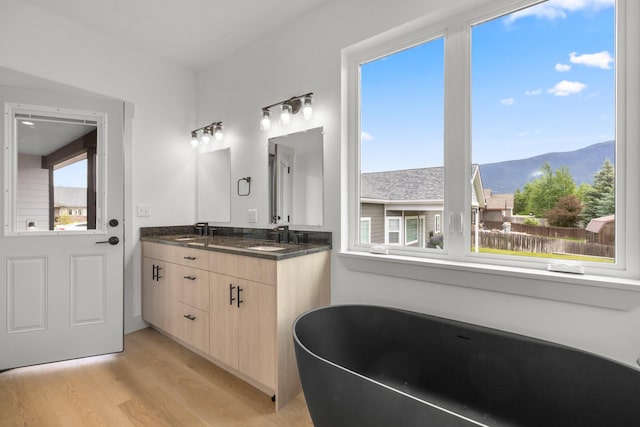 57 Hidden Cedar Loop, Columbia Falls, MT 59912 - full bathroom with a mountain view, a freestanding tub, wood finished floors, and double vanity
