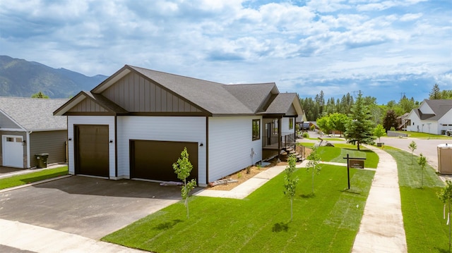 57 Hidden Cedar Loop, Columbia Falls, MT 59912 - view of front of property with a garage, board and batten siding, asphalt driveway, a front yard, and a mountain view