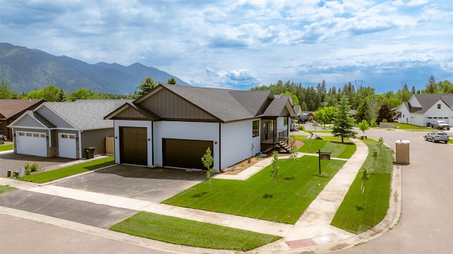 57 Hidden Cedar Loop, Columbia Falls, MT 59912 - view of front of house featuring an attached garage, asphalt driveway, a mountain view, a front yard, and a shingled roof